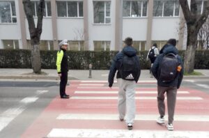 Imagine cu un polițist local care ajută pietonii în apropierea unei școli din Constanța