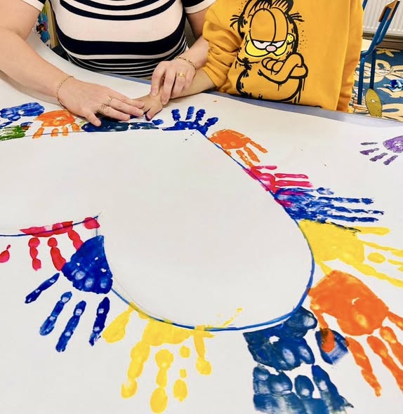 Copil și adult la o activitate creativă într-un centru pentru copii