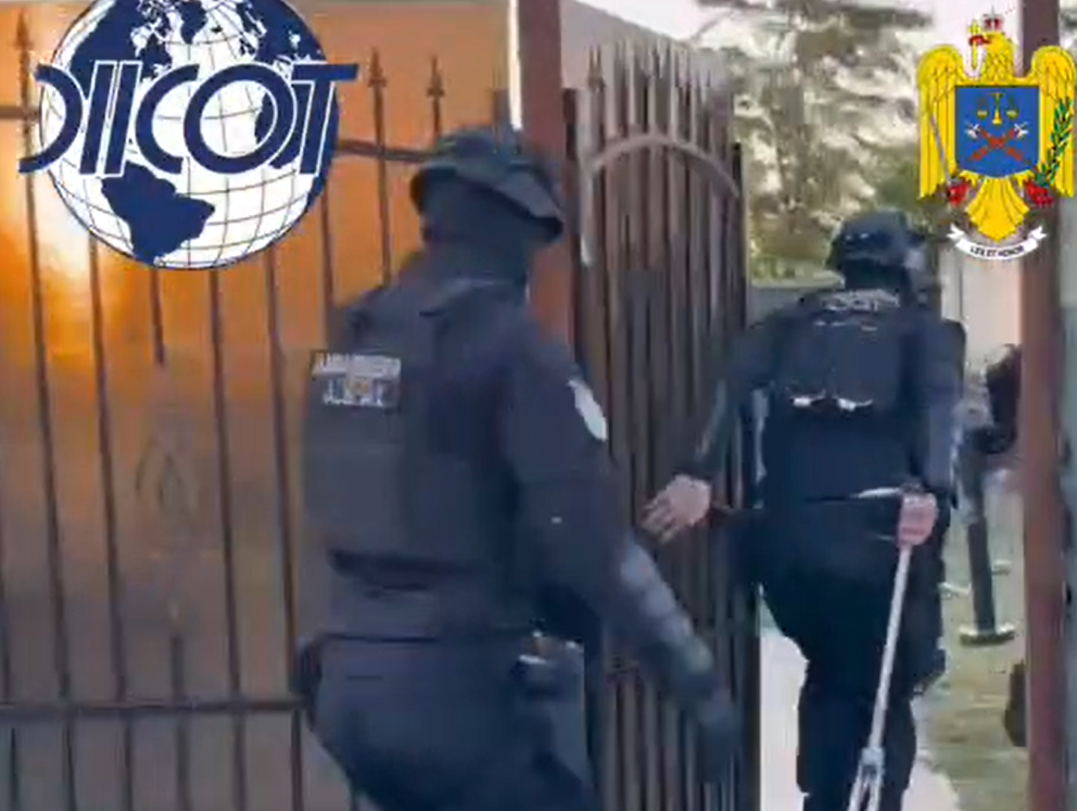 Polițiști DIICOT intră într-o curte în timpul unei acțiuni într-un dosar de droguri de mare risc la Constanța